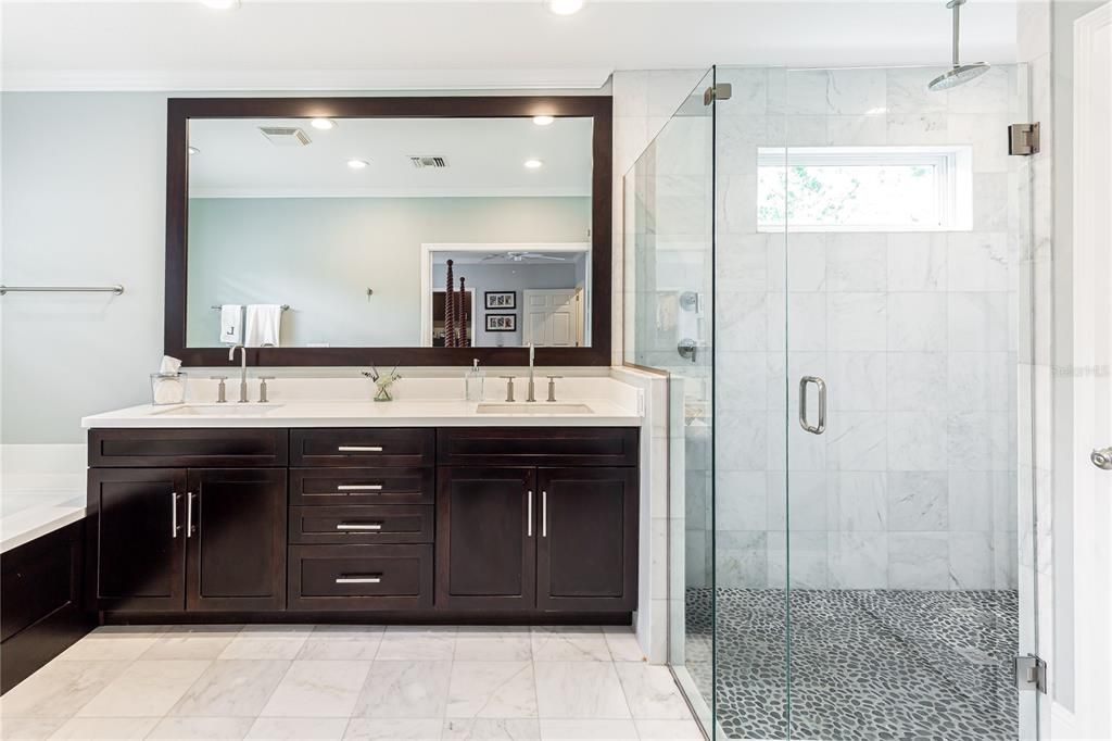 Sophistocated Seamless Glass Shower with rain-head and pebble flooring