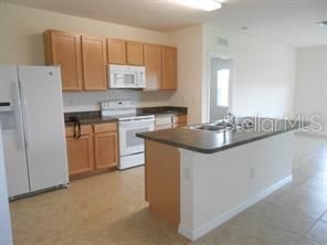 KITCHEN W/LARGE ISLAND BREAKFAST BAR, LOTS OF CABINETS AND COUNTERS, PANTRY TOO!