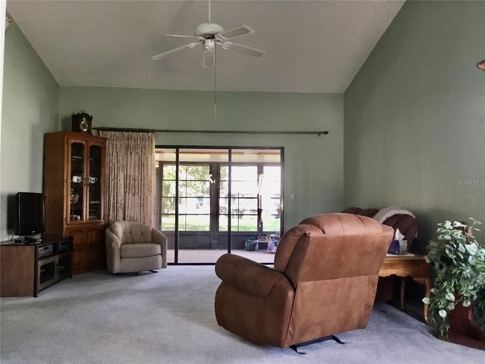 Living area with access to the Florida room, overlooking garden view and shady oaks.
