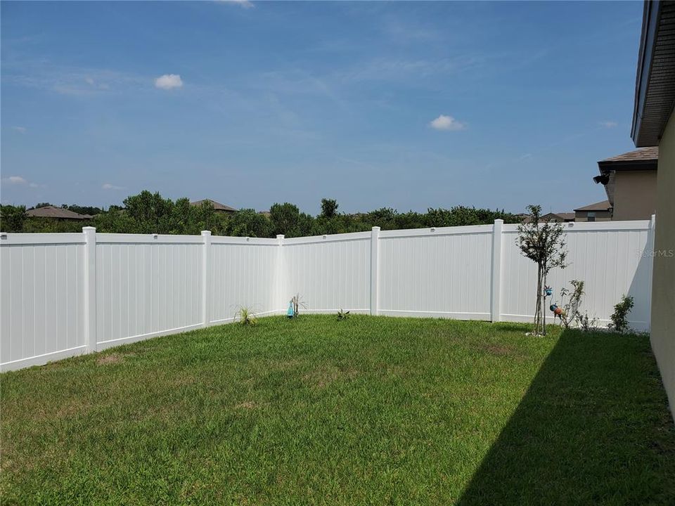 Fenced in yard with wooded area in back