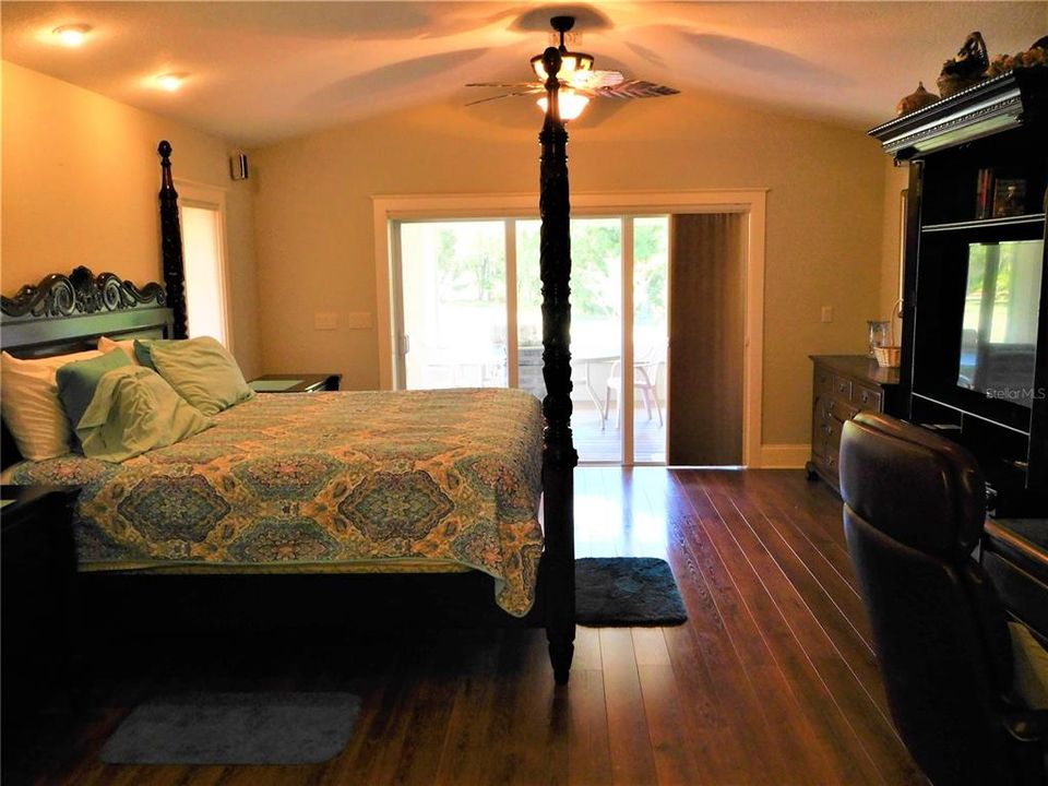 Inviting cathedral ceiling master suite with an attached outdoor kitchen lanai!