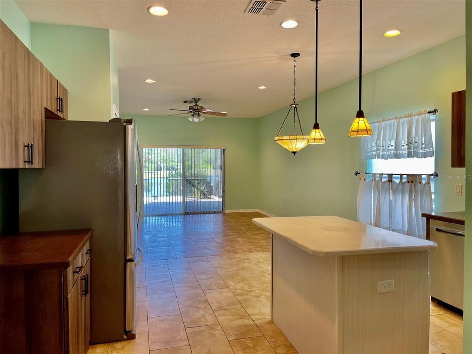 Standing in dining room doorway, looking through kitchen towards family room and back patio doors