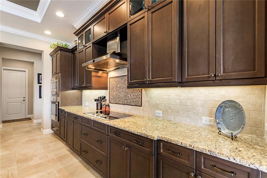 Fully tiled backsplash with mosaic tile accents above the cooktop.
