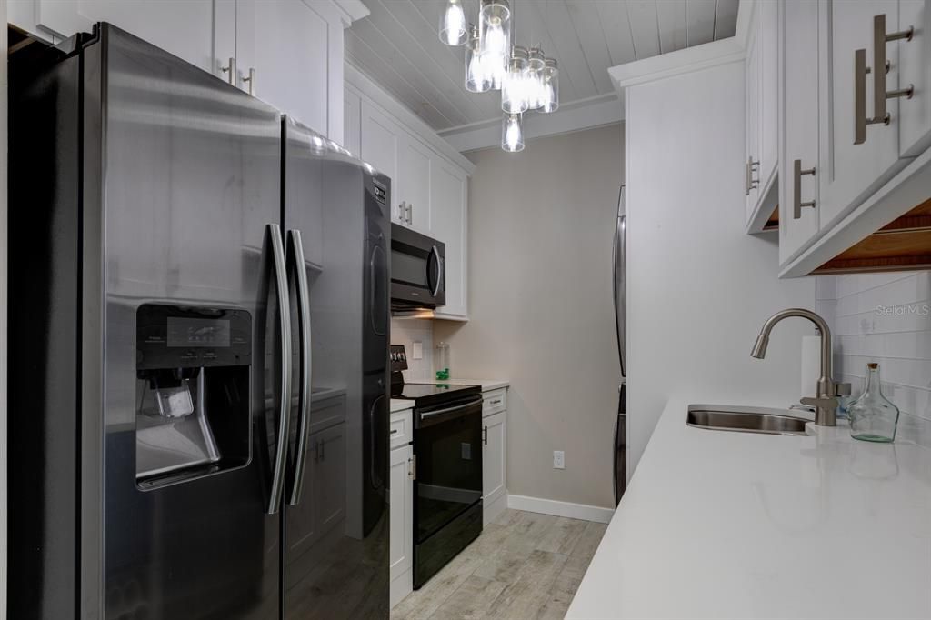 Laundry Room/Kitchenette Complete w/ Wine Cooler, Refrigerator, Stove, Microwave, W&D, Sink and plenty of storage.