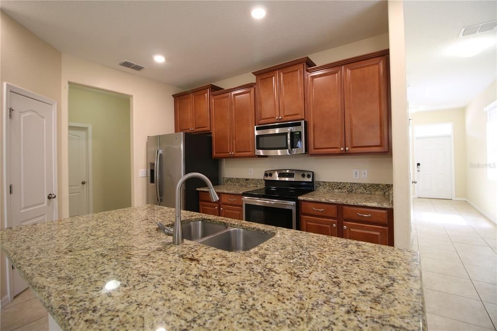 Kitchen with 42" wood cabinets, granite counters, glass top stove,