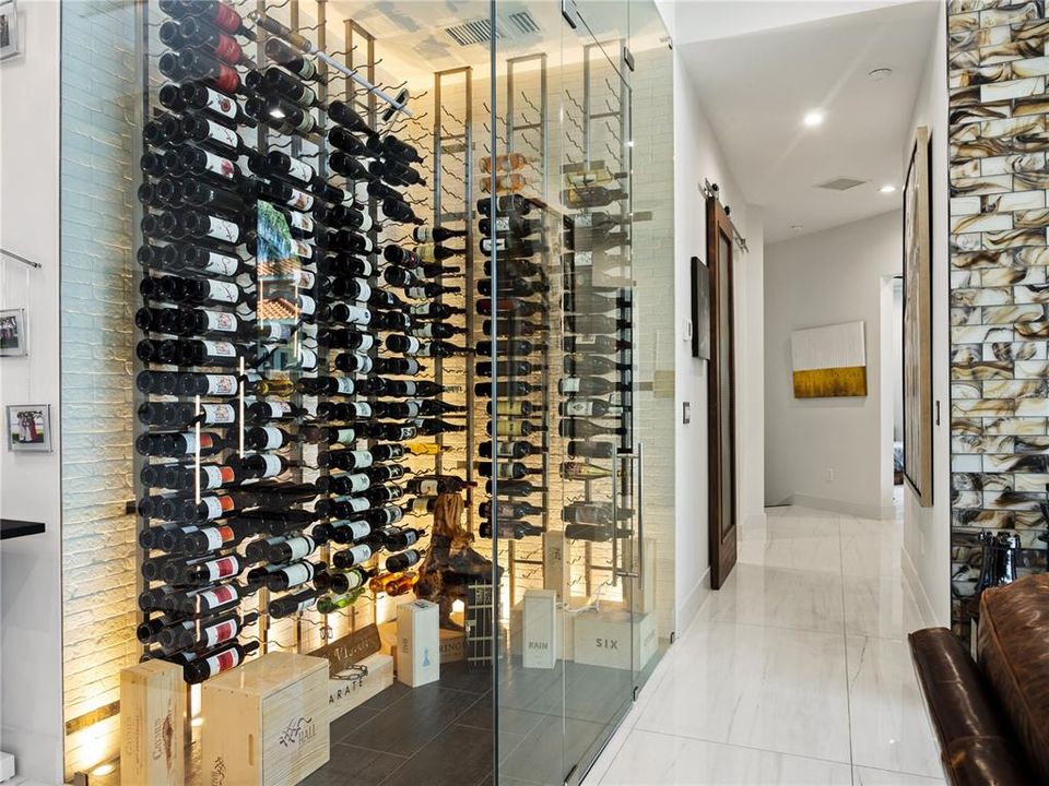 504-bottle capacity glass-encased wine cellar is a gorgeous centerpiece for the combined living space.