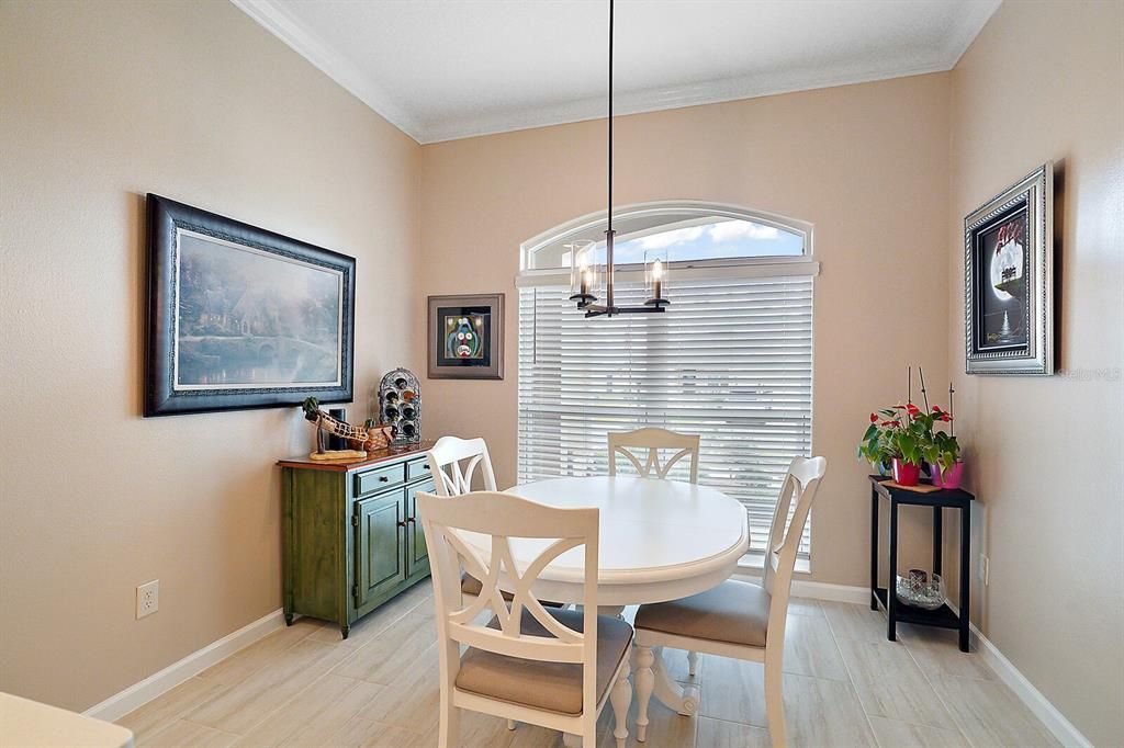 Eat in area of kitchen with vaulted ceiling and crown molding