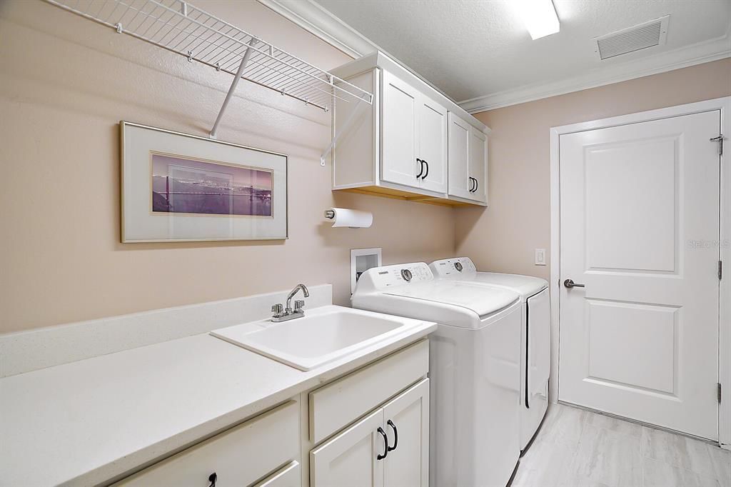 Inside laundry room with utility sink and extra cabinets