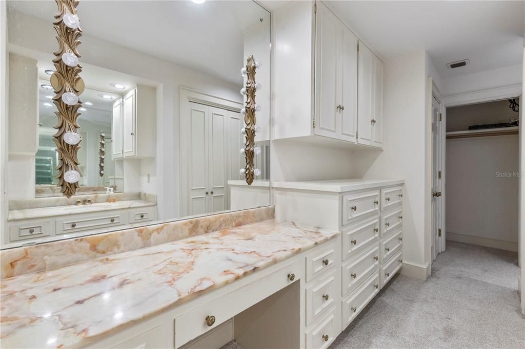 Pink Onyx Countertops and Tub/Shower enclosures highlight the master bathroom which is outfitted with plenty of custom storage features.