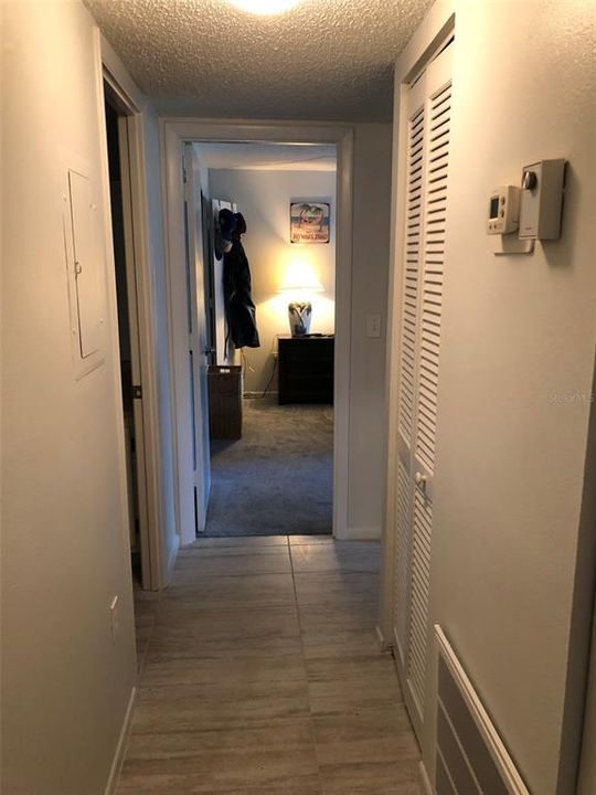 Hallway leading to two bedrooms and two bathrooms.