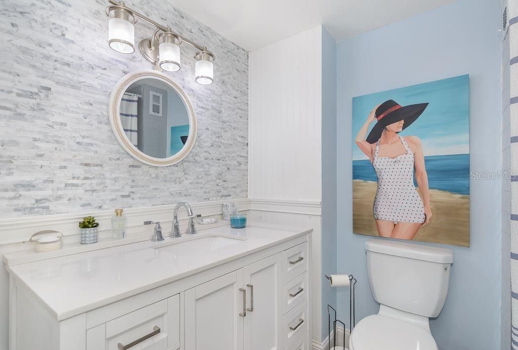The bathroom features an updated vanity and lighting fixtures.