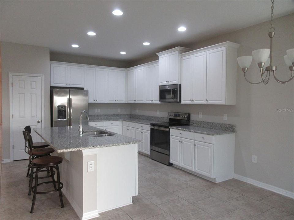 Gleaming white cabinets w/crown molding, granite counters, breakfast bar