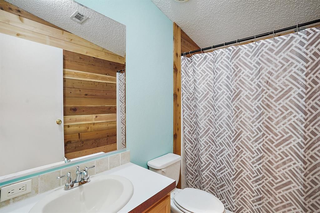 Hall bath with tub/shower and cedar wall feature ~