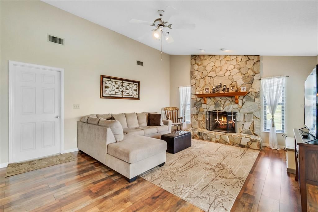 Family room features a Wood Burning Fireplace and New Wood Plank Laminate Flooring