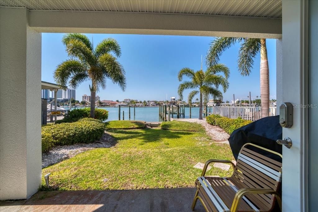 Doors exit to a private outdoor sitting area overlooking the water, your boat slip and pool to the right.
