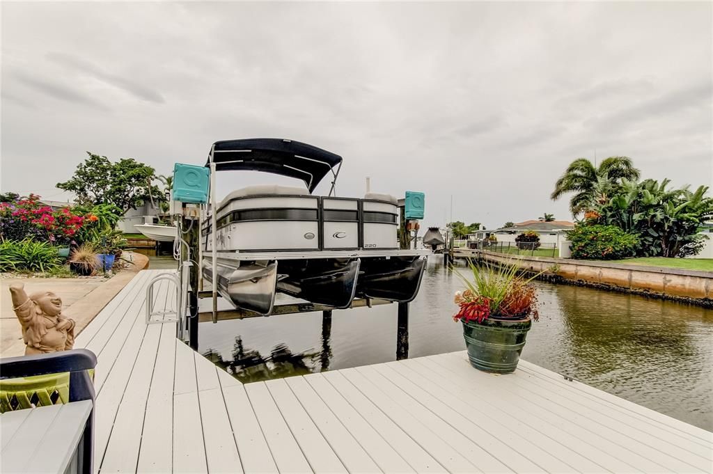 Dock area with pontoon boat. 7,000 lb. boat lift with davits.