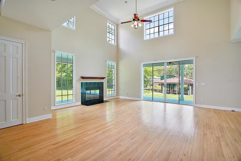 wood burning fireplace in main living room with sliding glass doors to back porch