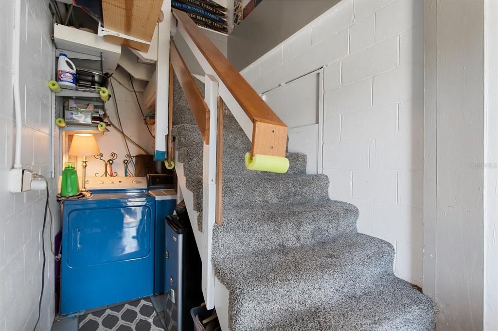 The stairs to the upstairs bedroom. Room for Washer & Dryer under steps. Extra storage space. Outside entrance is in front of stairs.
