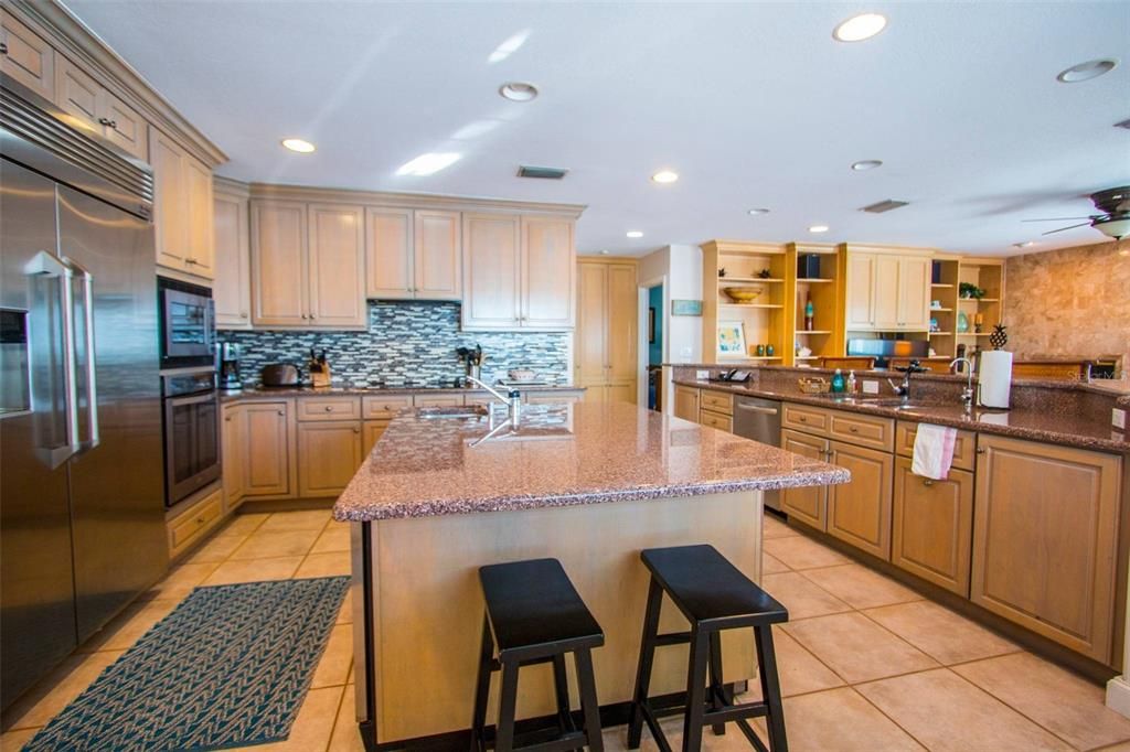 Kitchen with granite countertops and sub zero large refrigerator, built in oven, microwave and cooktop