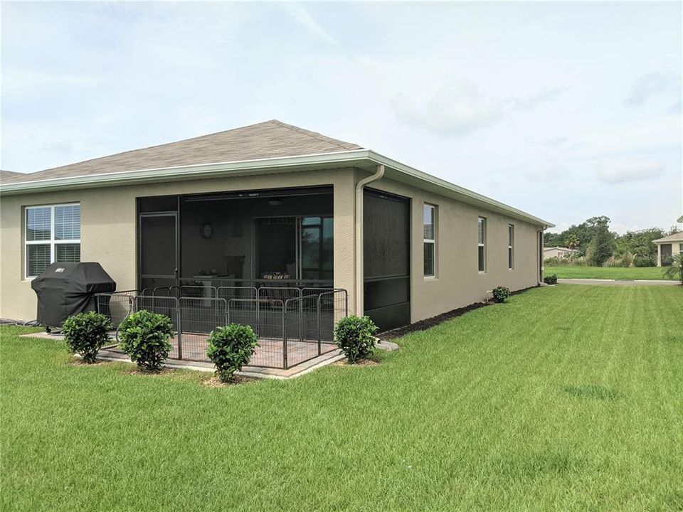 the back of the house with screened covered lanai and extended paved terrace