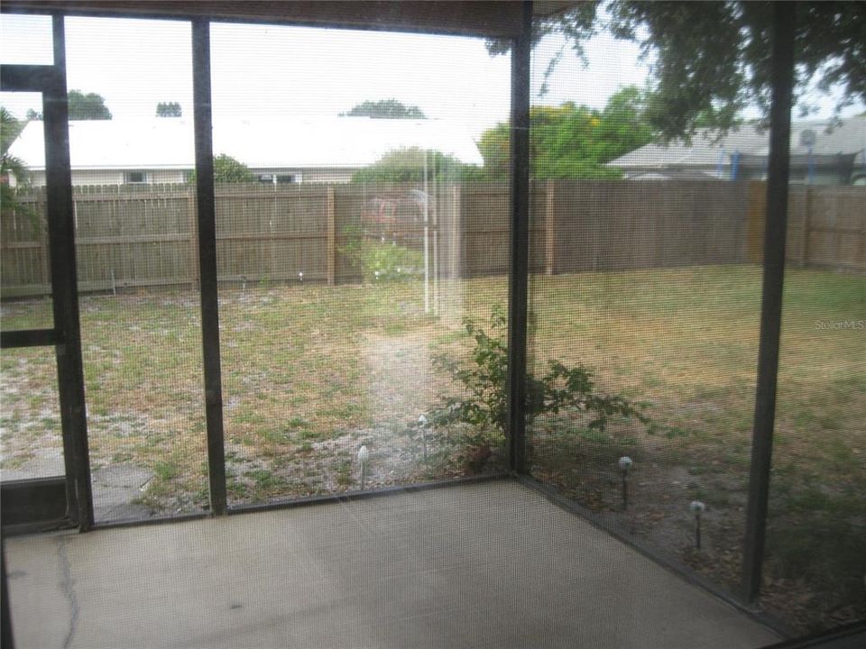 NICE SCREENED LANAI WITH PLENTY OF ROOM TO EAT OR ENTERTAIN ON LOOKS OUT TO FENCED BACKYARD.