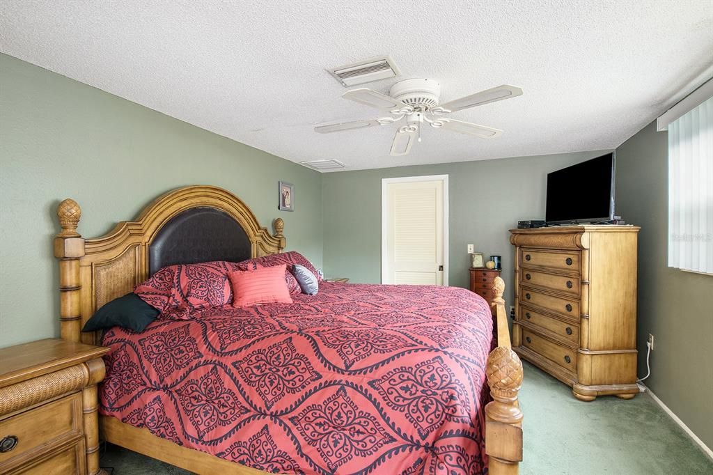 Master bedroom with ceiling fan and large window for natural light!