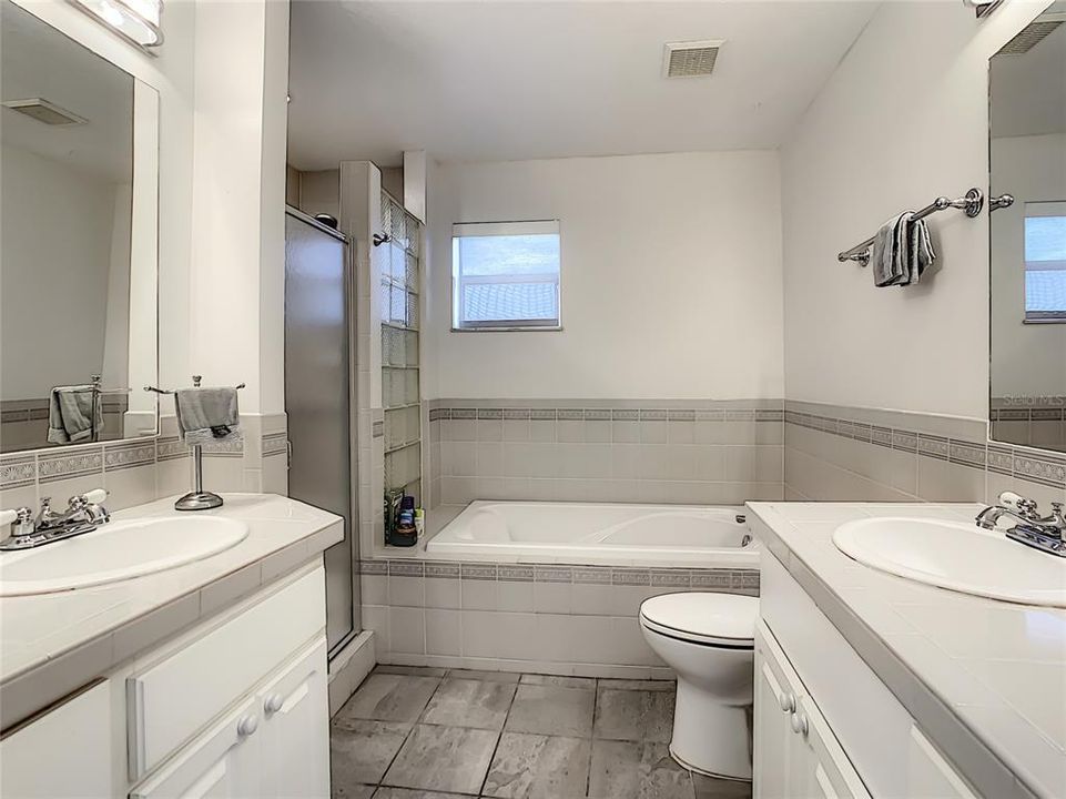 Full guest bathroom with two vanities, tub and shower