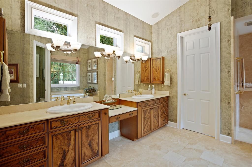 Spa-like bath with 2 sinks, travertine dual-head shower, 2 water closets with bidet.
