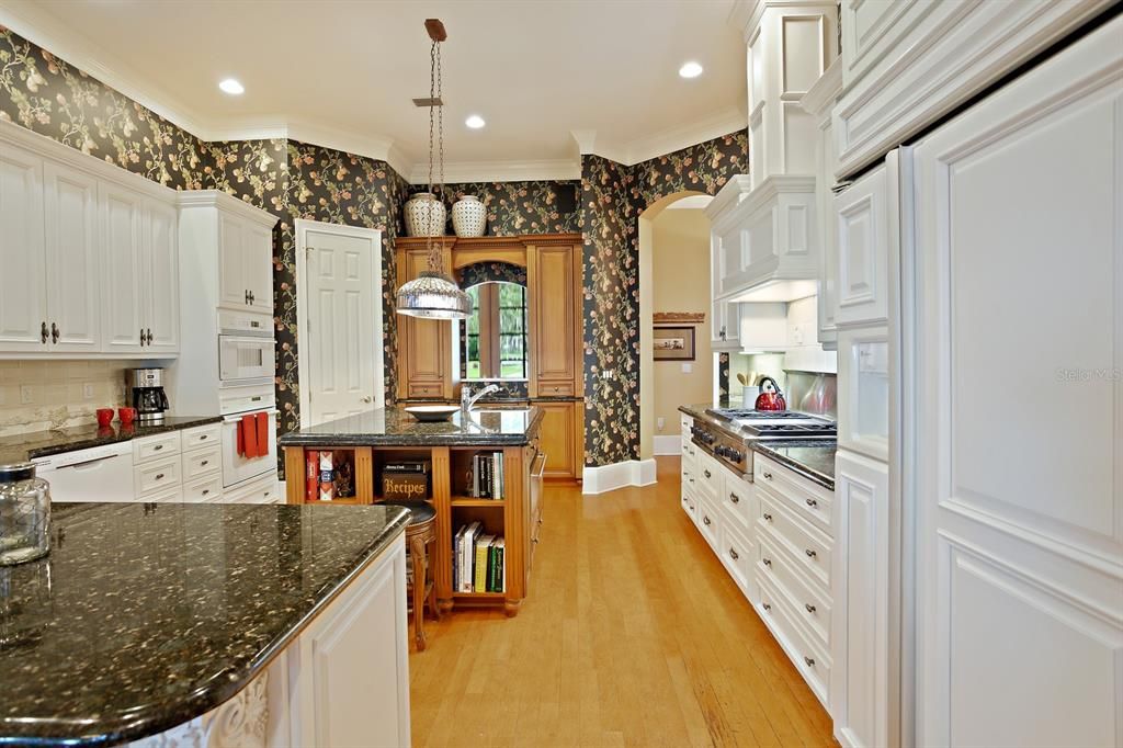 Custom tile backsplash, granite counters, white appliances, and 6-burner gas range
