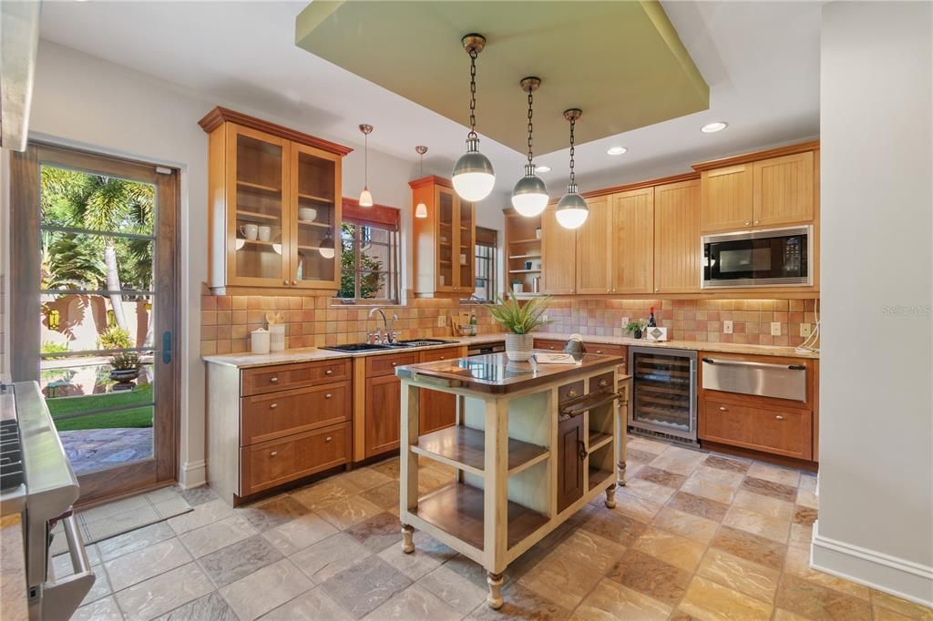 Kitchen features a 60" Wolf gas range with a double oven, side by side Sub-Zero Refrigerators, Wolf microwave, Sub-Zero wine fridge, Asko Dishwasher and warming drawer