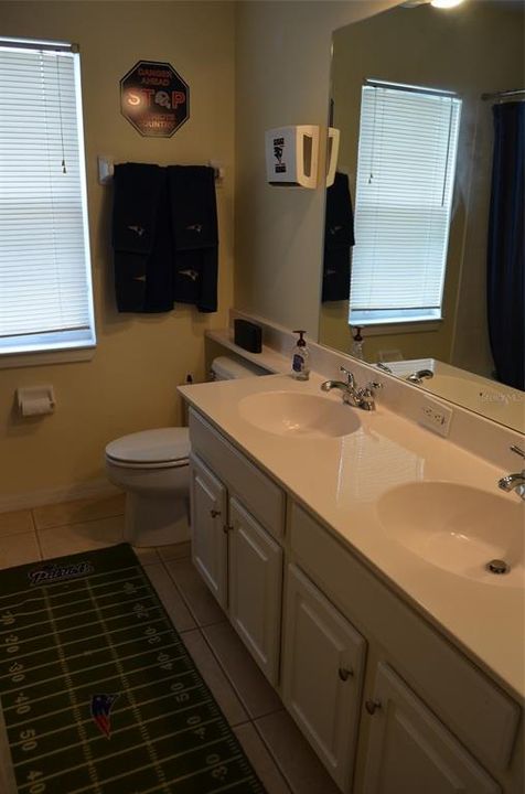 Upstairs bathroom with dual vanity and shower/tub combo.