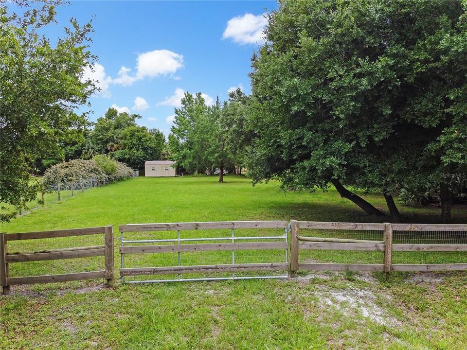 Additional pasture with storage shed and fencing.