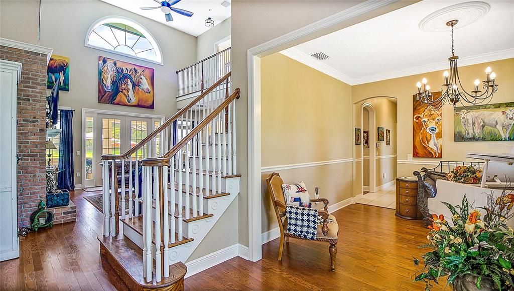Standing in the foyer you can appreciate the beautiful dining room, lovely oak staircase and upper balcony, and the view beyond the living room onto the expansive rear porch and lanai.