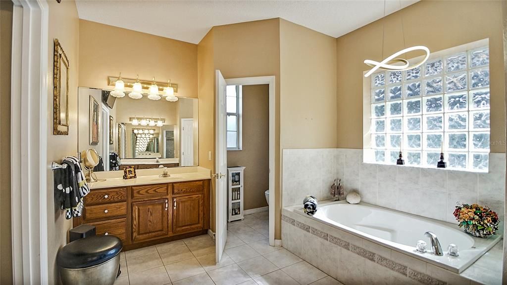 An inviting garden tub, private water closet and one of the two vanities in the master bath.