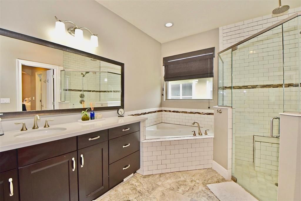 Master bath has dual vanities, large jetted garden tub, and separate walk in shower with upgraded tile & Rain Shower head. Tankless Water Heater for continuous hot water during showering.