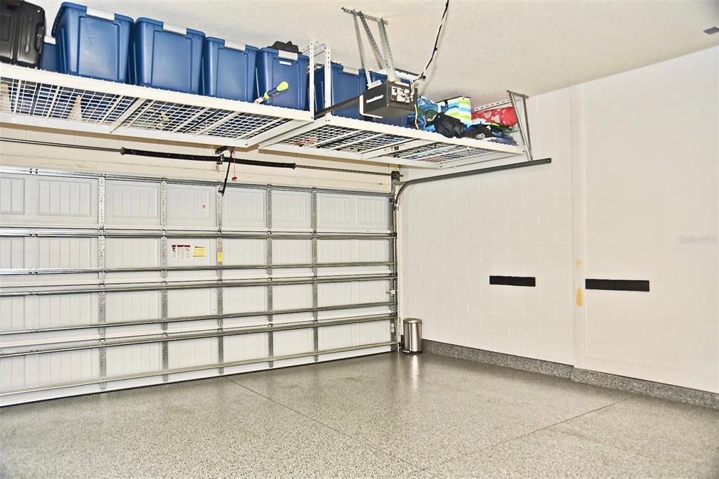 3 Car Garage with Epoxy Floors, Custom Cabinet Storage, & Ceiling Racks.