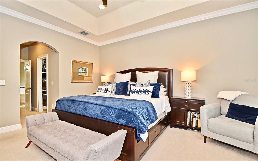 Spacious first floor master suite featuring tray ceilings and 2 large walk in closets both with custom closet built-ins.