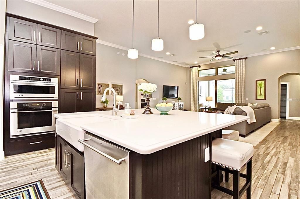 Large island with gorgeous quartz countertops and beautiful surround beardboard, all over looking the spacious great room and sparkling pool!