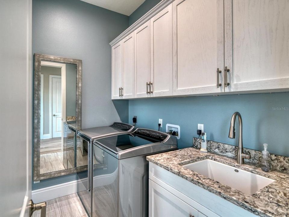 Laundry room has separate utility sink and additional storage.