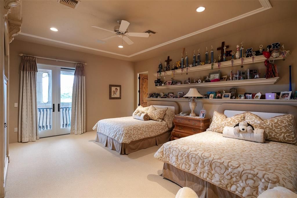 Bedroom suite #2 features a large walk-in closet, custom built-in shelving and a Juliet balcony overlooking the pool.