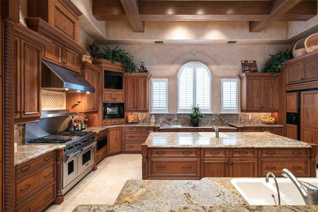 Carved wooden cabinetry and smooth granitecountertops in the kitchen complement the expansiveisland.