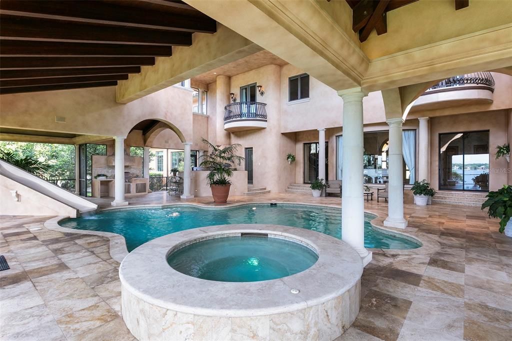 Surrounded by beautifully maintained travertine floors, the pool lanai is an ideal extension to the interior estate.