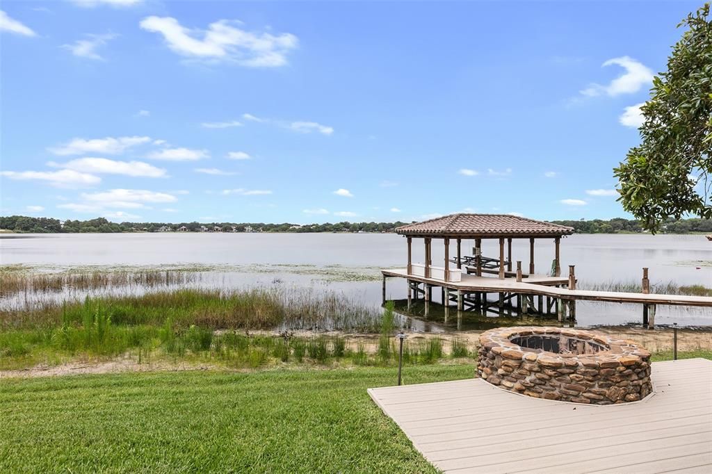 A custom gas firepit is ready to be enjoyed as the sun goes down over the private lake.