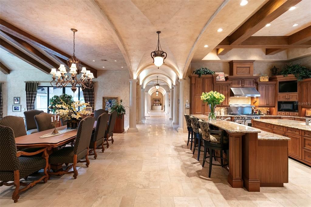 Sprawling travertine floors lead to the home???s maingathering area comprised of the gourmet kitchen anddining area overlooking the sunken living room.