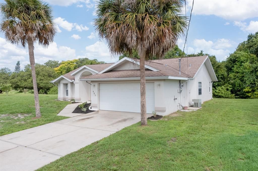 Nice curb appeal! Mature palm trees, cement driveway. Simple and ready for your personal touches.