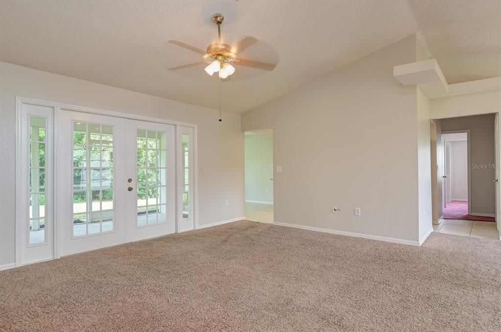 French doors provide great open view, and nice access to Lanai. Arch to right of doors leads to kitchen, opening to the next right lead to laundry, 2 bedrooms and guest bath.