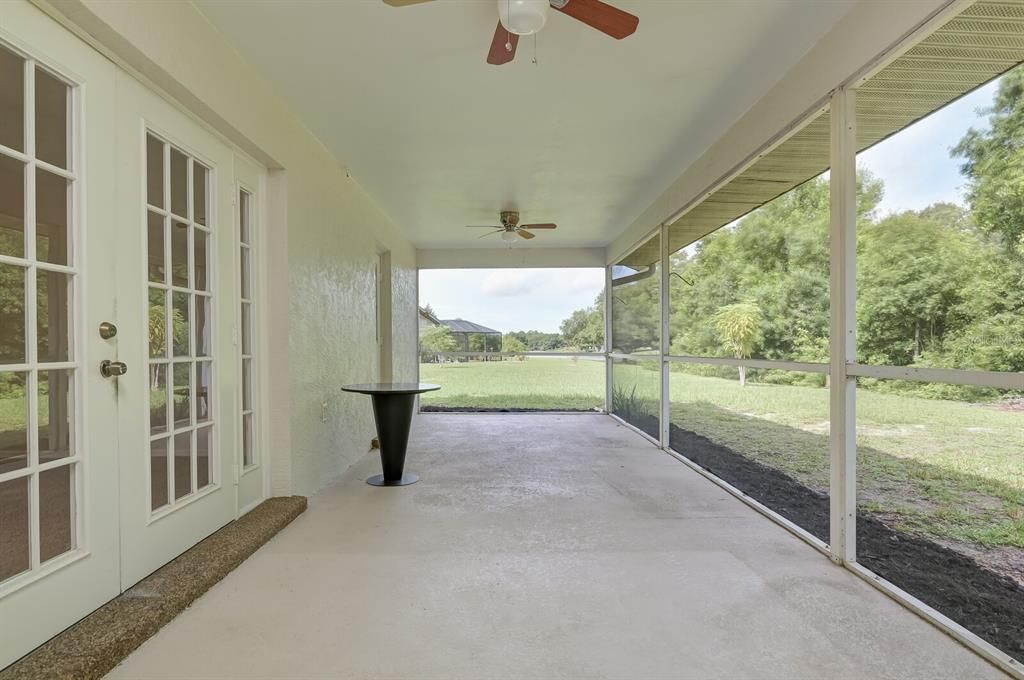 Screen Lanai runs along the back side of home. Ceiling fan/lights newly installed. French doors are to the Living Rm/Great Room. The other door is to main bedroom bathroom.