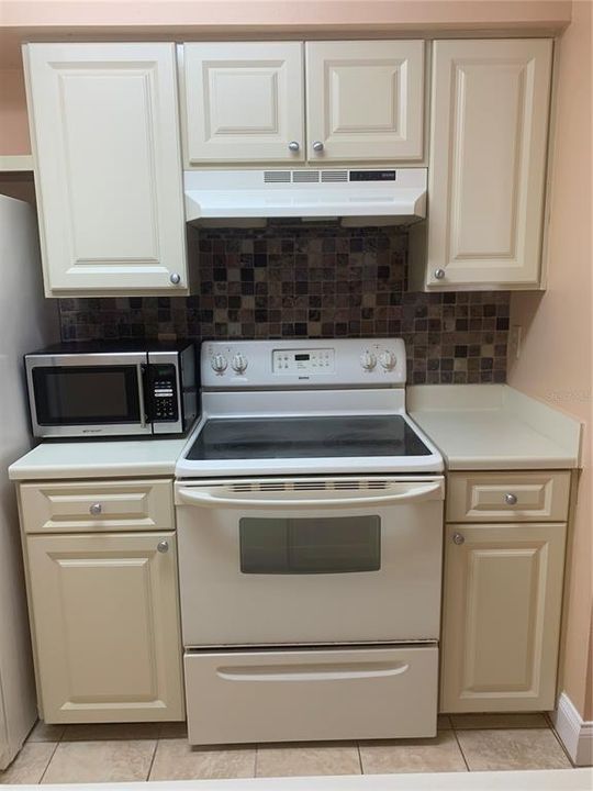 Designer backsplash, Refrigerator, microwave, stove, dishwasher, even toaster oven along with a sizable indoor laundry room right off of the kitchen.