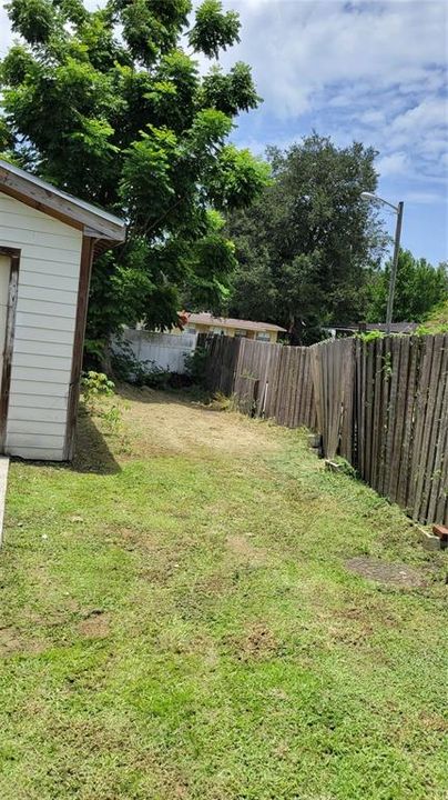 Side yard right with shed/fence.