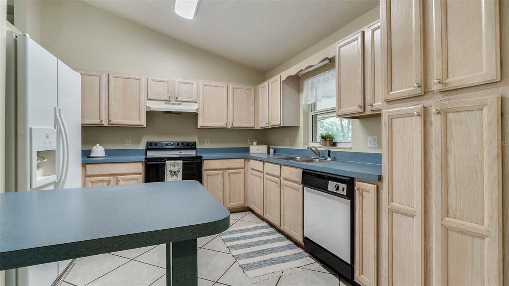 Kitchen with window looking to back yard a breakfast bar